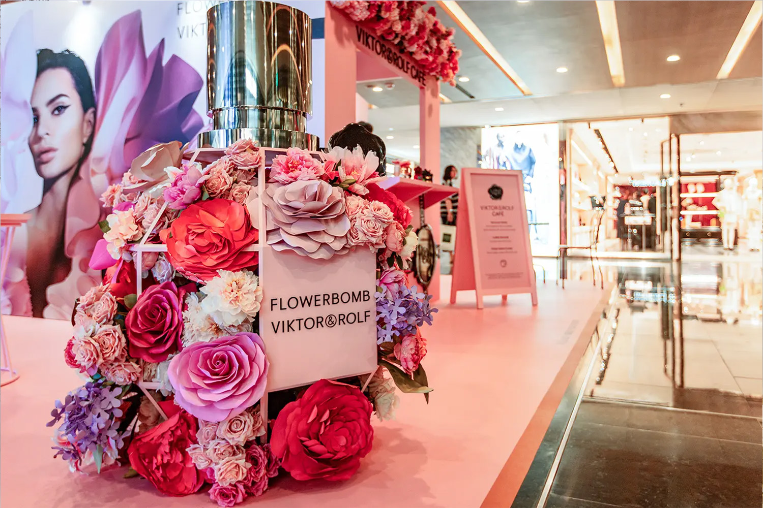 Flowerbomb Viktor&Rolf perfume display adorned with vibrant flowers at a mall